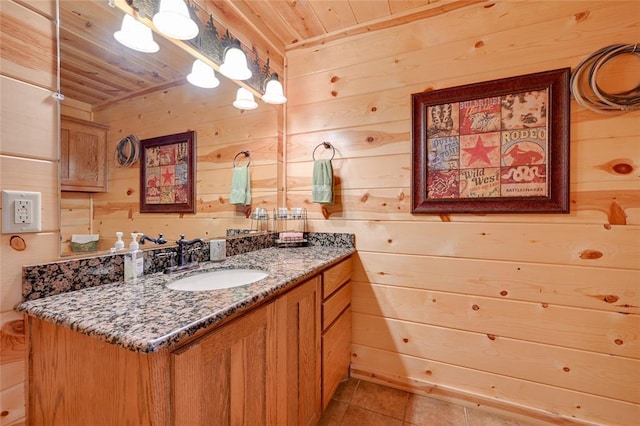 bathroom featuring wooden walls, wooden ceiling, tile patterned flooring, and vanity