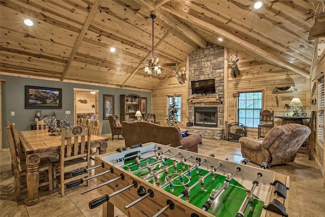 recreation room with a fireplace, wooden ceiling, beam ceiling, a ceiling fan, and high vaulted ceiling