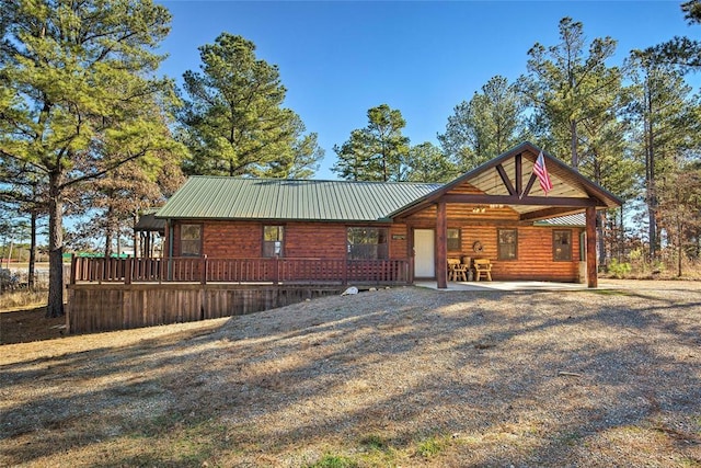back of property featuring metal roof and log veneer siding