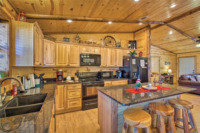 kitchen with black appliances, a sink, light wood finished floors, wooden ceiling, and a kitchen breakfast bar