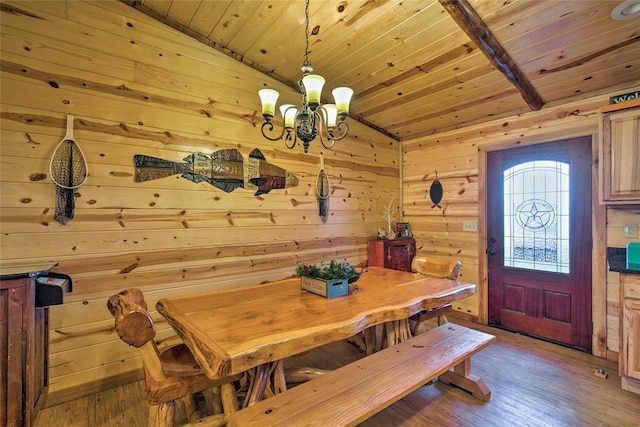 dining space with a chandelier, wooden ceiling, wood walls, wood finished floors, and vaulted ceiling