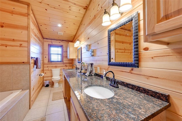 bathroom featuring wooden walls, toilet, double vanity, tile patterned floors, and a relaxing tiled tub