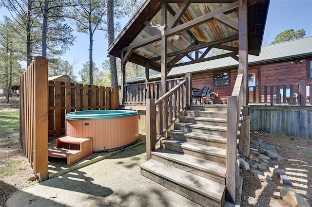 wooden deck featuring a hot tub and a patio area