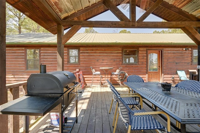 wooden terrace with outdoor dining area, grilling area, and a gazebo