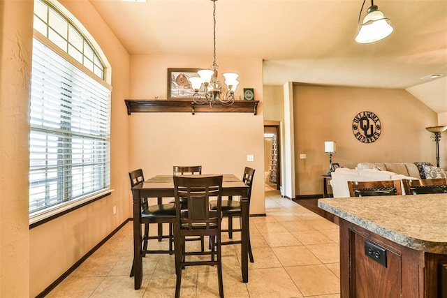 dining area with light tile patterned floors, a notable chandelier, visible vents, baseboards, and lofted ceiling