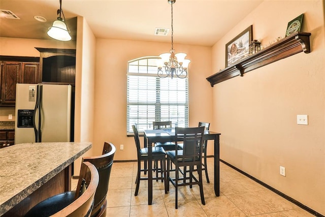 dining space featuring an inviting chandelier, visible vents, baseboards, and light tile patterned flooring