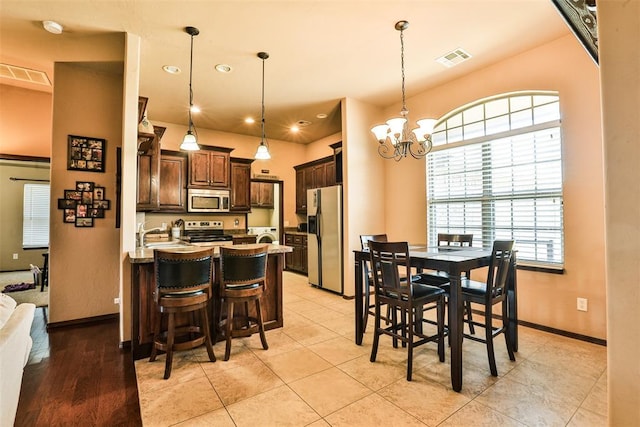 dining area featuring an inviting chandelier, visible vents, and a healthy amount of sunlight