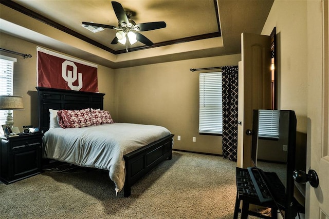 carpeted bedroom featuring ornamental molding, visible vents, ceiling fan, a raised ceiling, and baseboards