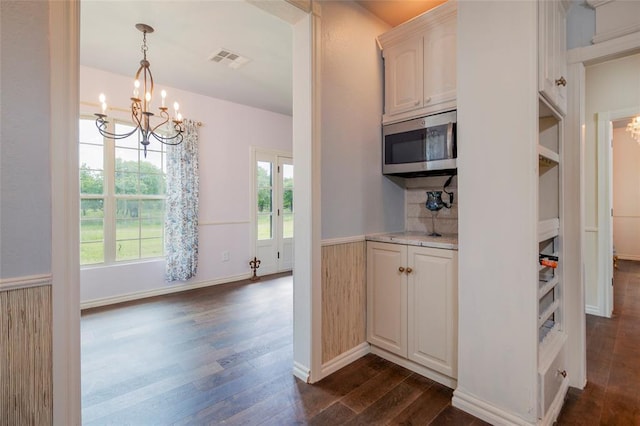 13403 NE 225th St, Fletcher, OK 73541 - kitchen featuring stainless steel microwave, a chandelier, dark wood finished floors, plenty of natural light, and a wainscoted wall