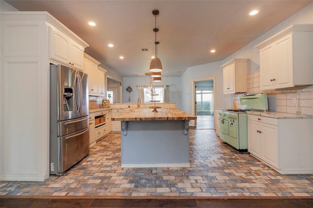 13403 NE 225th St, Fletcher, OK 73541 - kitchen with stainless steel refrigerator with ice dispenser, white gas range oven, a center island, recessed lighting, and backsplash
