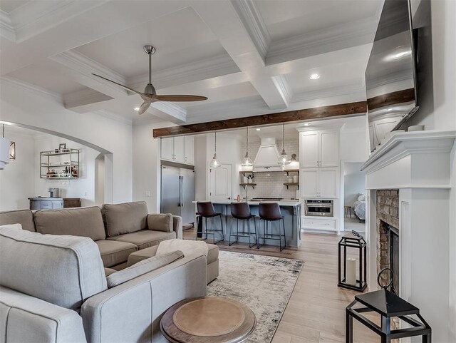 8509 NW 125th St, Oklahoma City, OK 73142 - living area with a ceiling fan, light wood-style floors, beamed ceiling, coffered ceiling, and arched walkways
