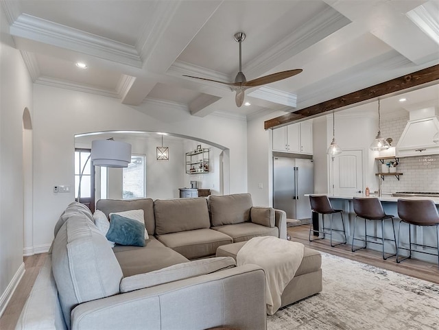 8509 NW 125th St, Oklahoma City, OK 73142 - living area featuring arched walkways, a ceiling fan, light wood-style floors, ornamental molding, and beam ceiling