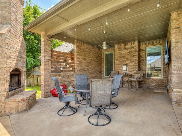8509 NW 125th St, Oklahoma City, OK 73142 - view of patio / terrace with an outdoor brick fireplace, outdoor dining area, and fence