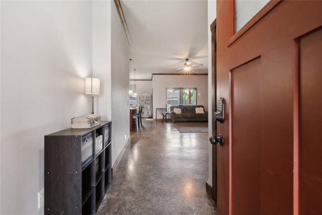 hallway featuring concrete flooring and baseboards