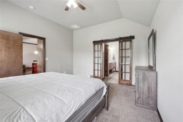 bedroom with lofted ceiling, carpet, a barn door, ensuite bathroom, and ceiling fan