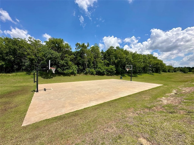 view of basketball court with community basketball court and a lawn