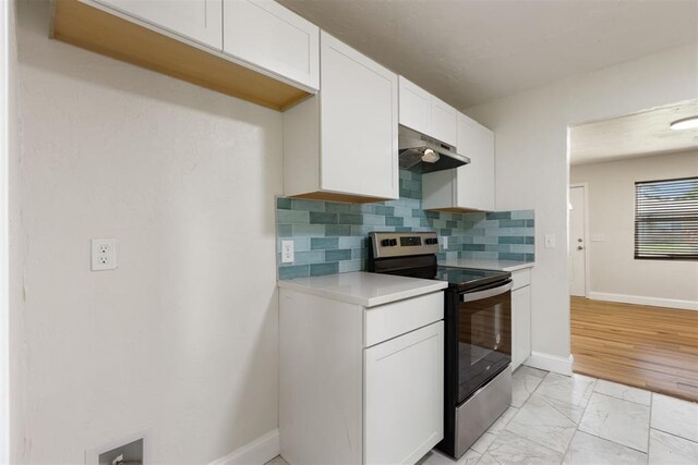 1225 NW 99th St, Oklahoma City, OK 73114 - kitchen featuring stainless steel electric stove, under cabinet range hood, light countertops, decorative backsplash, and white cabinetry