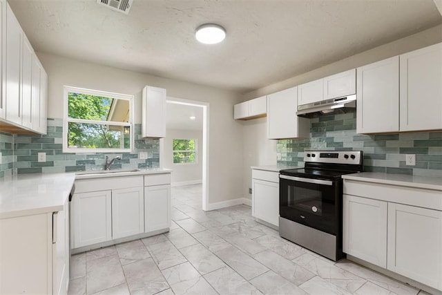 1225 NW 99th St, Oklahoma City, OK 73114 - kitchen with stainless steel electric range oven, a sink, under cabinet range hood, light marble finish floors, and light countertops