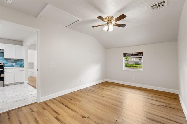 1225 NW 99th St, Oklahoma City, OK 73114 - unfurnished room with attic access, lofted ceiling, light wood finished floors, baseboards, and ceiling fan