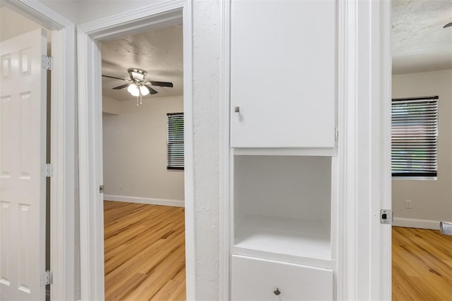 1225 NW 99th St, Oklahoma City, OK 73114 - hallway with wood finished floors, baseboards, and a textured ceiling