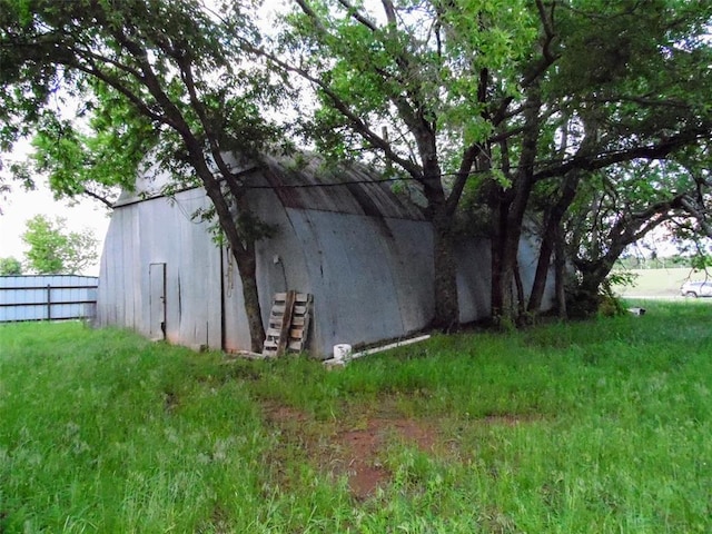 view of outdoor structure featuring fence and an outdoor structure