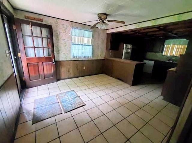 17 S Cemetery Rd, Tuttle, OK 73089 - kitchen featuring wooden walls, wainscoting, ceiling fan, and tile patterned floors