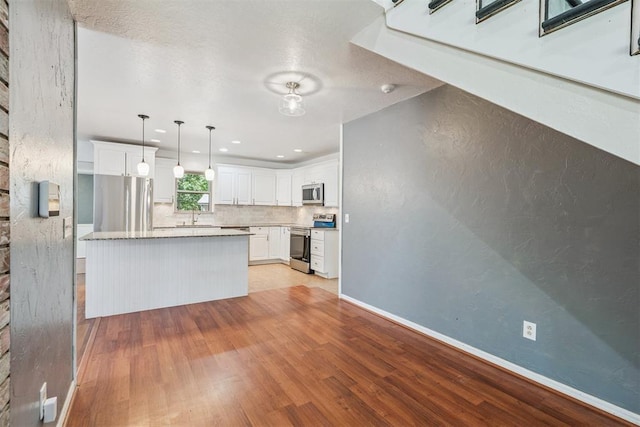 2220 NW 47th St, Oklahoma City, OK 73112 - kitchen featuring appliances with stainless steel finishes, light wood-type flooring, white cabinets, decorative backsplash, and recessed lighting