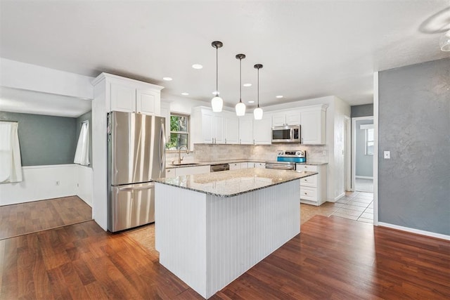 2220 NW 47th St, Oklahoma City, OK 73112 - kitchen with appliances with stainless steel finishes, wood finished floors, light stone counters, white cabinets, and recessed lighting