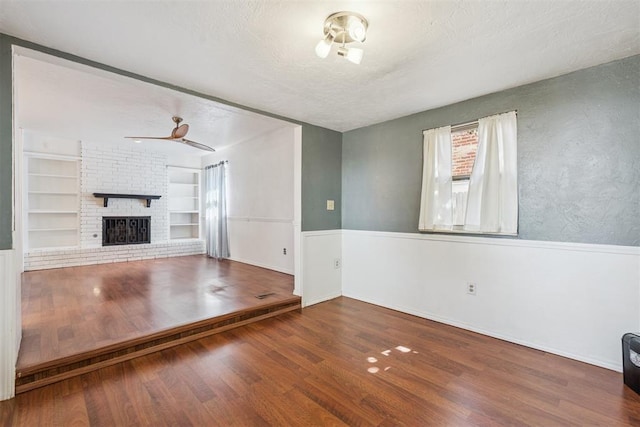 2220 NW 47th St, Oklahoma City, OK 73112 - unfurnished living room featuring wood finished floors, a fireplace, a textured ceiling, and ceiling fan