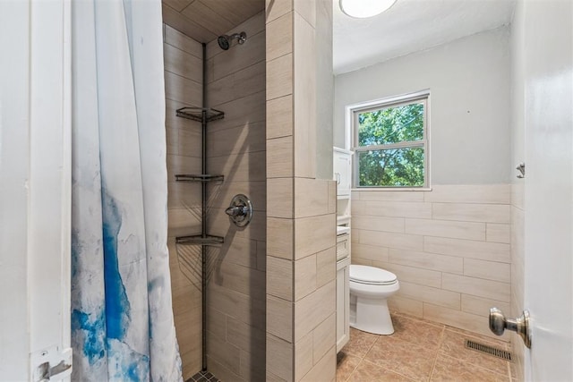 2220 NW 47th St, Oklahoma City, OK 73112 - bathroom featuring tile walls, tiled shower, tile patterned floors, and wainscoting