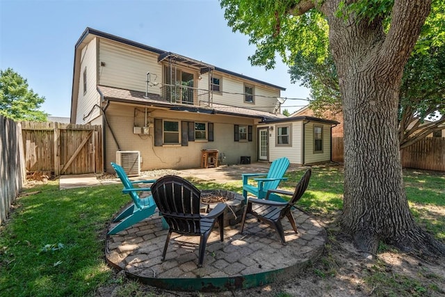 2220 NW 47th St, Oklahoma City, OK 73112 - rear view of house with a balcony, a fire pit, brick siding, a fenced backyard, and a gate