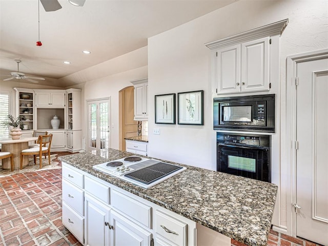 2417 Pawnee Xing, Edmond, OK 73034 - kitchen with black appliances, ceiling fan, brick floors, white cabinetry, and recessed lighting