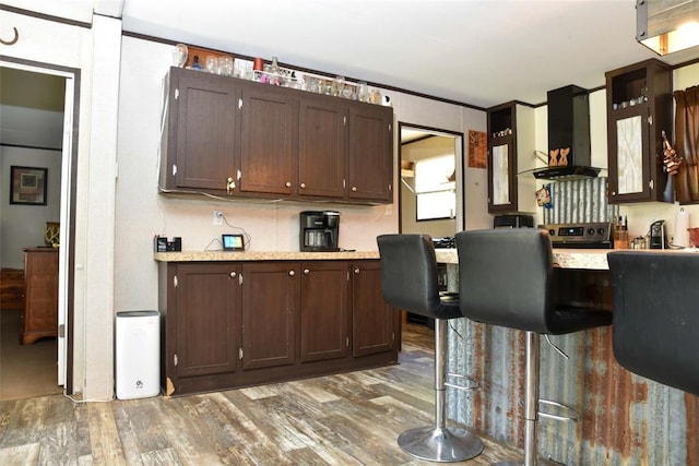 300746 Mcaly Rd, Foster, OK 73434 - bar featuring wall chimney range hood, wood finished floors, and stainless steel electric range oven