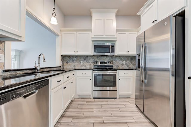 kitchen with white cabinetry, stainless steel appliances, and a sink