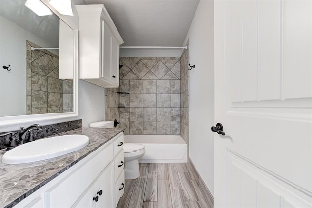 bathroom featuring toilet, vanity, and tub / shower combination