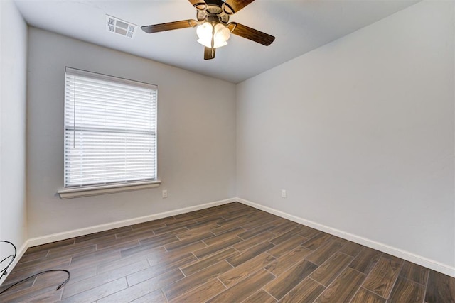 empty room featuring baseboards, visible vents, and wood finished floors