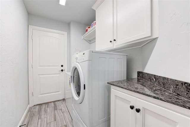 washroom with washer / dryer, light wood-type flooring, and cabinet space