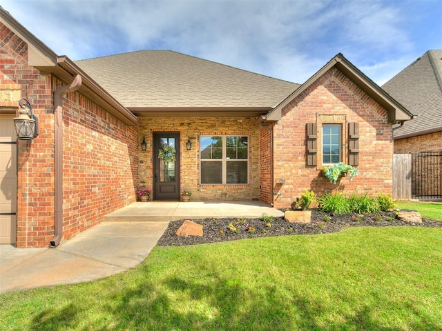 1808 Lago Dr, Moore, OK 73160 - property entrance featuring brick siding, a shingled roof, and a garage