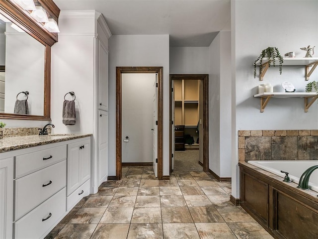 1808 Lago Dr, Moore, OK 73160 - bathroom featuring baseboards, vanity, a garden tub, and a walk in closet