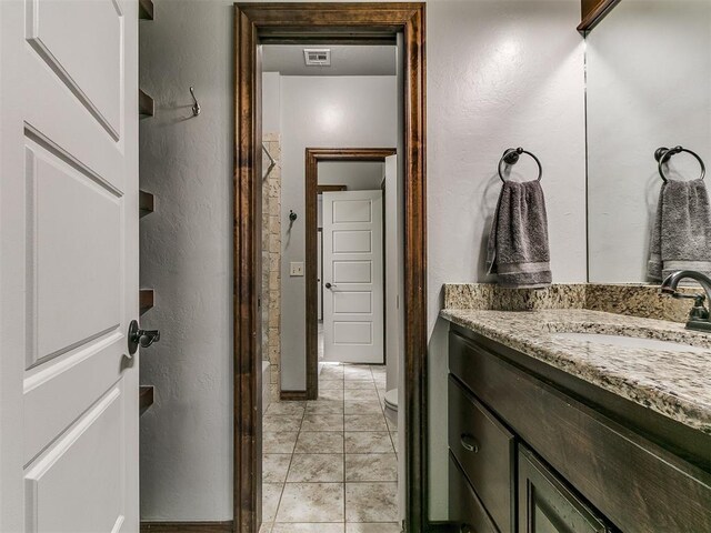 1808 Lago Dr, Moore, OK 73160 - bathroom featuring vanity, a textured wall, toilet, tile patterned flooring, and baseboards