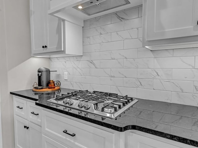 8332 Poplar Dr, Edmond, OK 73034 - kitchen with stainless steel gas stovetop, custom range hood, white cabinetry, backsplash, and dark stone counters