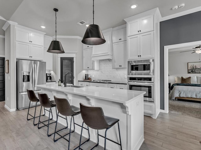 8332 Poplar Dr, Edmond, OK 73034 - kitchen with appliances with stainless steel finishes, white cabinets, light wood-type flooring, decorative backsplash, and recessed lighting