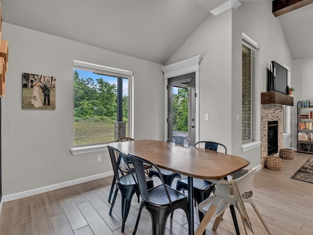 8332 Poplar Dr, Edmond, OK 73034 - dining area featuring lofted ceiling, a fireplace, and light wood-style floors