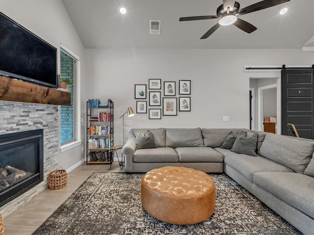 8332 Poplar Dr, Edmond, OK 73034 - living room featuring a barn door, a fireplace, wood finished floors, ceiling fan, and recessed lighting