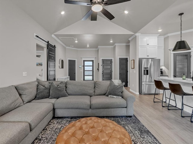 8332 Poplar Dr, Edmond, OK 73034 - living area with a barn door, ceiling fan, light wood finished floors, ornamental molding, and vaulted ceiling
