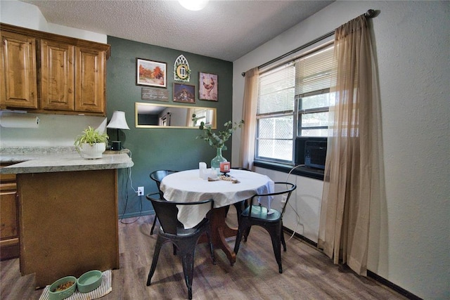 1208 Cathy Ln, Oklahoma City, OK 73110 - dining area featuring wood finished floors, a textured ceiling, baseboards, and cooling unit