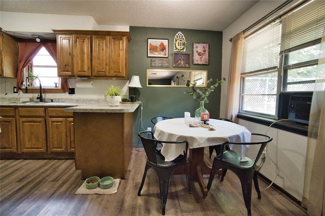 1208 Cathy Ln, Oklahoma City, OK 73110 - kitchen with dark wood-type flooring, brown cabinetry, a textured ceiling, light countertops, and a sink