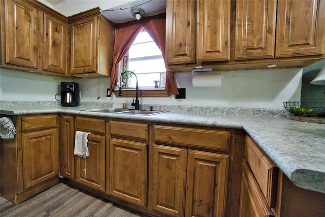 1208 Cathy Ln, Oklahoma City, OK 73110 - kitchen with a sink, brown cabinetry, wood finished floors, and light countertops