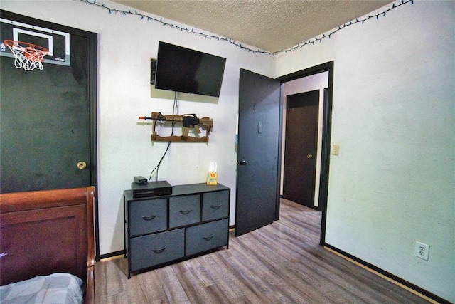 1208 Cathy Ln, Oklahoma City, OK 73110 - bedroom featuring a textured ceiling, wood finished floors, and baseboards
