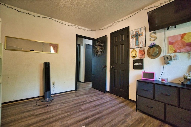 1208 Cathy Ln, Oklahoma City, OK 73110 - bedroom featuring dark wood finished floors, a textured ceiling, and baseboards